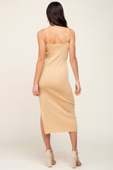 woman wearing a beige ribbed midi dress with spaghetti straps and side slit, viewed from the back