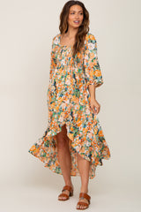woman wearing orange floral smocked high-low maternity midi dress with brown sandals