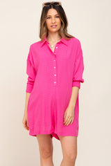 Woman wearing a bright pink button-down romper with long sleeves and a collar against a neutral background