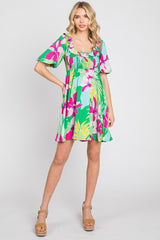 woman wearing a colorful floral print short dress with puff sleeves and a smocked bodice