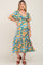 woman wearing a blue floral maternity dress with a flowy skirt and short sleeves, showing her baby bump