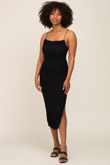 woman wearing a black fitted midi dress with ruched detailing and thin spaghetti straps