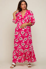 woman wearing a pink floral maxi maternity dress and holding her baby bump