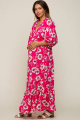 woman wearing a hot pink floral maternity maxi dress and holding her baby bump
