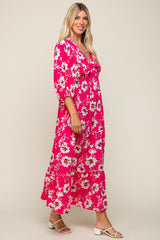 woman wearing a bright pink floral maxi dress with puffed sleeves and a tiered skirt