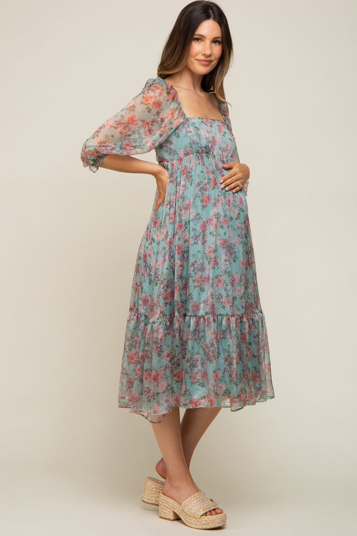 pregnant woman in a light blue floral maternity midi dress with puff sleeves and woven platform sandals