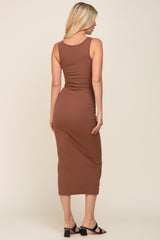 Back view of a blonde woman wearing a brown ribbed midi tank dress and black heeled sandals