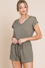 woman wearing olive green v-neck short sleeve romper with drawstring waist and pockets