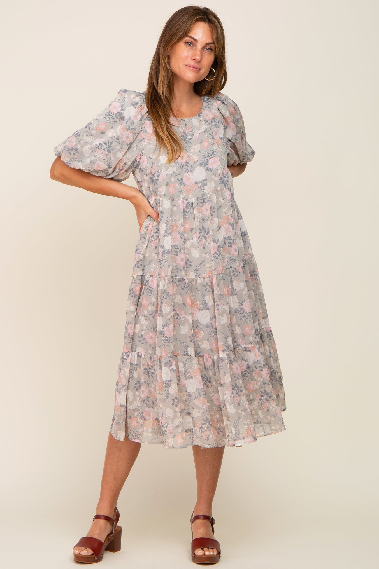 woman wearing a light grey floral tiered midi dress with puff sleeves and brown platform sandals