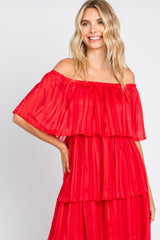 woman wearing a red off-the-shoulder pleated maxi dress with tiered layers and short sleeves