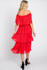 woman wearing a red off-the-shoulder tiered maxi dress with sheer fabric and layered ruffles, viewed from the back