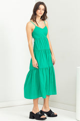 woman wearing a green tiered midi dress with spaghetti straps and black platform sandals