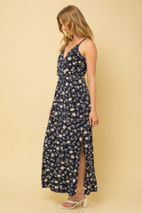 woman wearing a navy blue floral maxi dress with a side slit and white block heel sandals