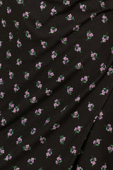 close up of black ribbed fabric with small purple floral print pattern