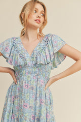 woman wearing a light blue floral maxi dress with ruffled sleeves and a smocked waist