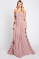 woman wearing a blush strapless long gown with ruching details and flowing skirt