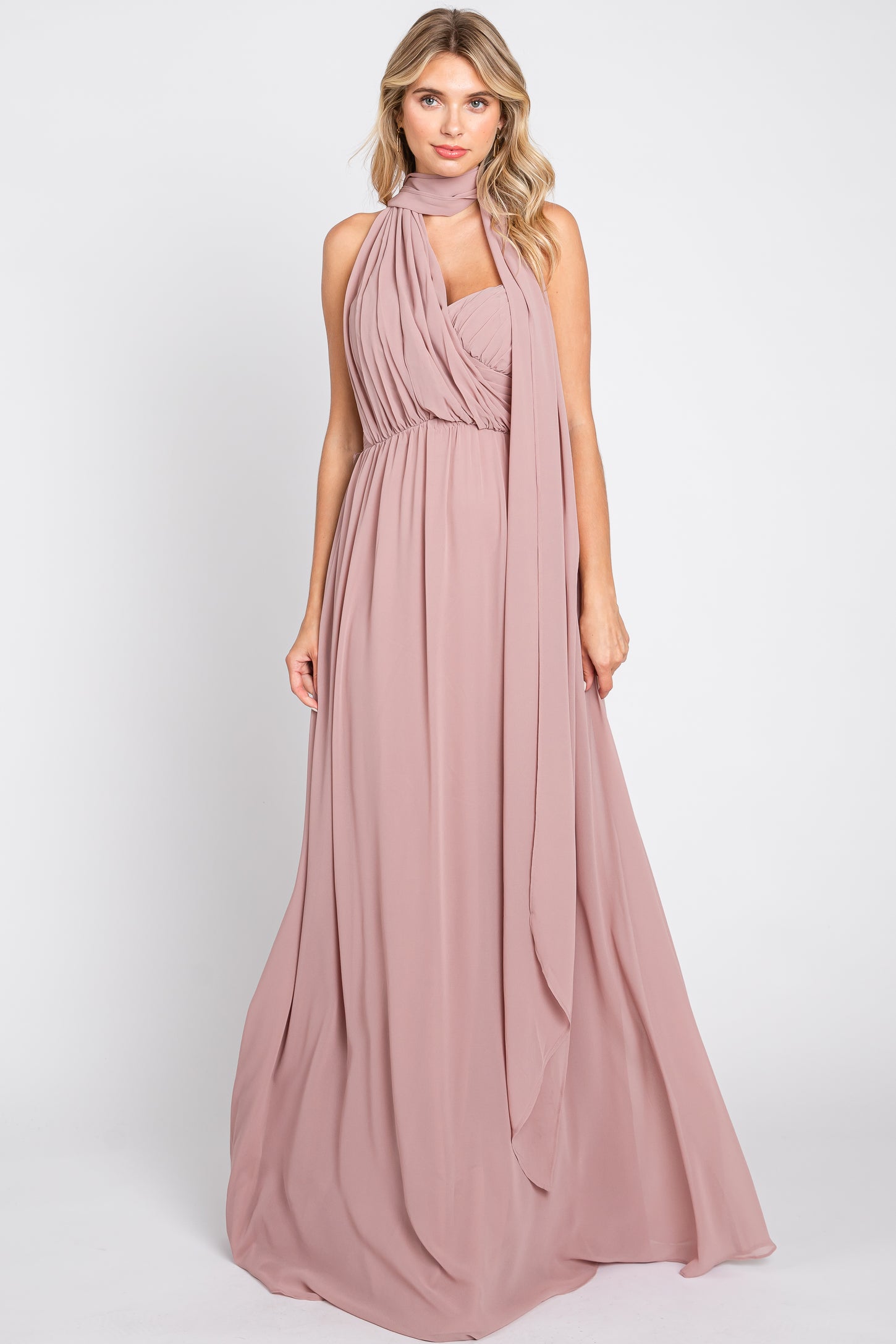 woman wearing a long blush pink maxi dress with a draped bodice and scarf detail