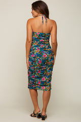 woman wearing a multicolored floral print maternity dress with ruching and a halter neck from the back