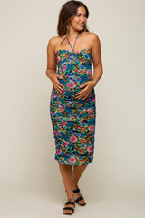 woman wearing a floral maternity dress with a sweetheart neckline and ruching, holding her baby bump