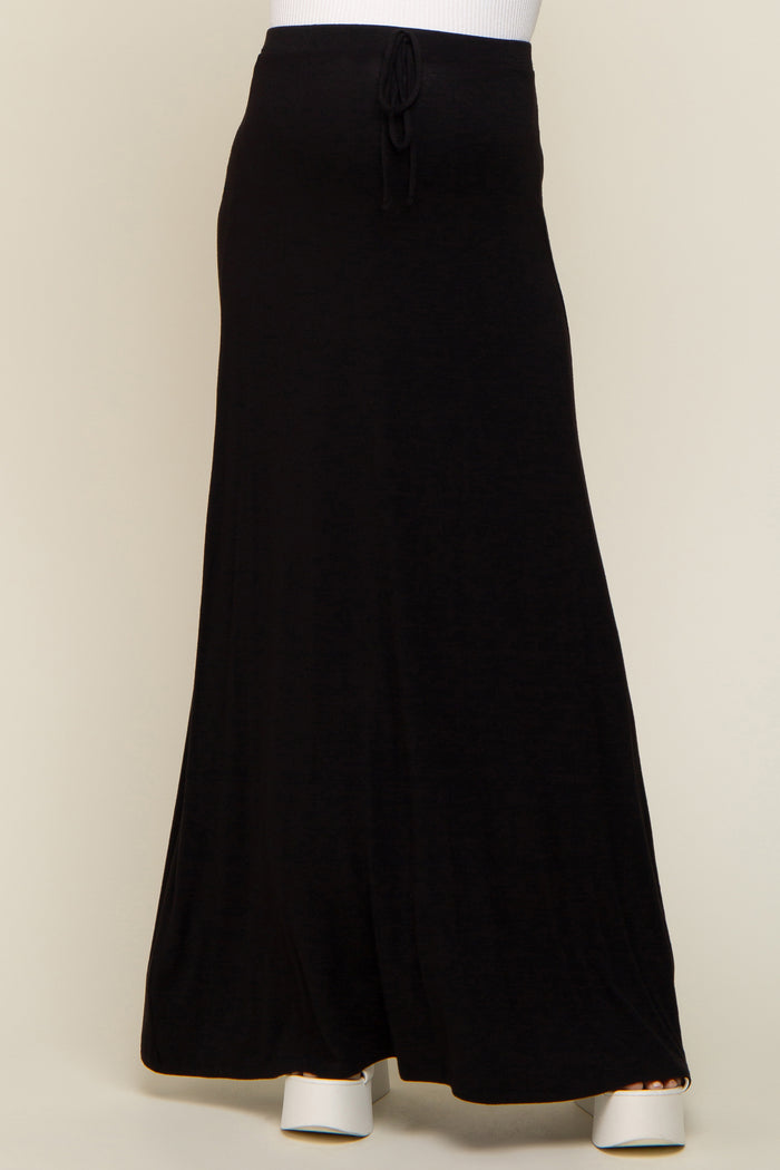 person wearing a long black drawstring maxi skirt with white platform sandals