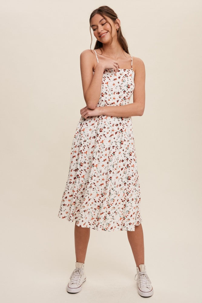 woman wearing a white floral midi dress with spaghetti straps and white high-top sneakers