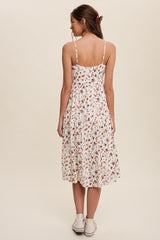 woman wearing a white floral midi dress with adjustable straps and a flowy silhouette, shown from the back