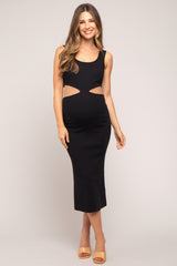 woman wearing a black maternity midi dress with cut-out details and showing her baby bump