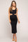 woman wearing a black maternity midi dress with cut-out details and showing her baby bump