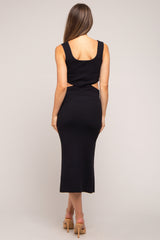 woman wearing a black ribbed maternity dress with a cut-out detail and a fitted silhouette