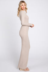 woman wearing a fitted beige long sleeve maxi dress, side view showing its snug silhouette and floor-length design