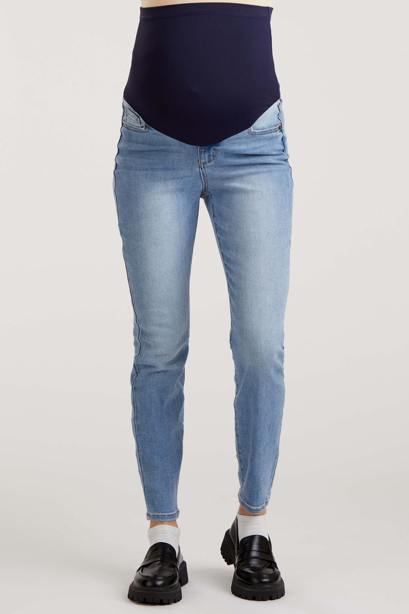 woman wearing blue skinny maternity jeans with a navy over-the-bump panel