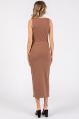 woman wearing a fitted brown ribbed maxi dress, showing the back view and styled with black heeled sandals