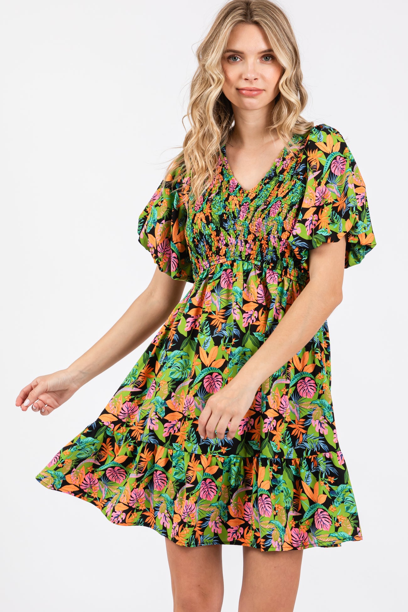 woman wearing a colorful floral print short dress with puff sleeves and a smocked bodice