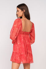 woman wearing a red floral print mini dress with puff sleeves and an open back