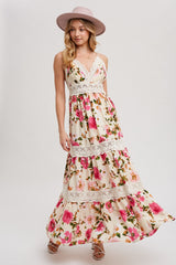 woman wearing a floral maxi dress with lace detailing and a wide-brimmed pink hat