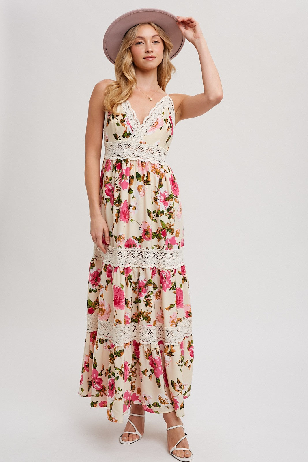 woman wearing a floral maxi dress with lace details and a wide-brimmed hat